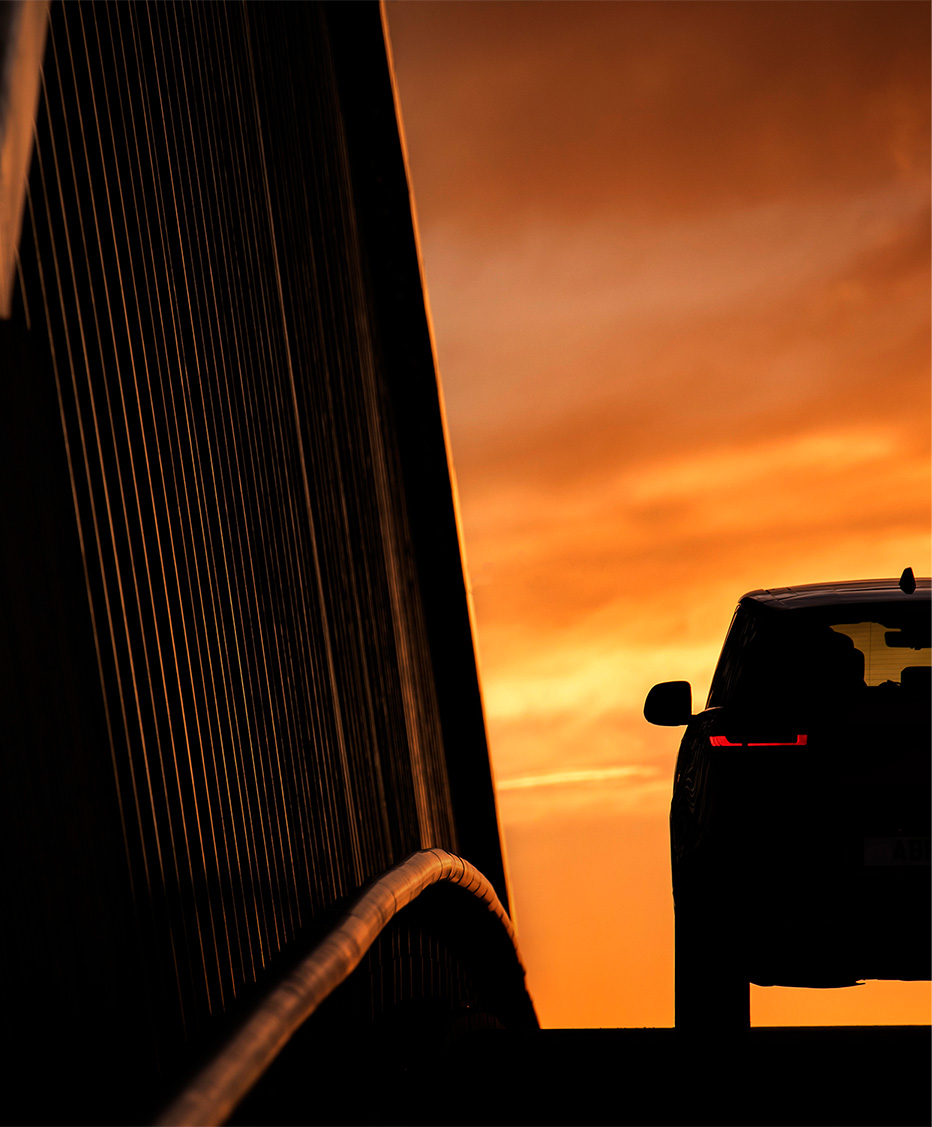 Land Rover driving on bridge during sunset